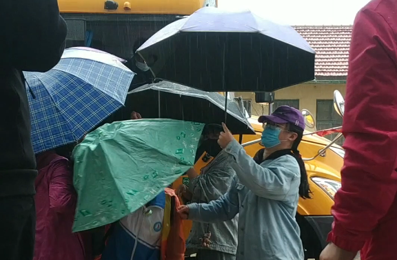 暖心!日照初三开学!东港实验学校老师们雨中排队打伞!