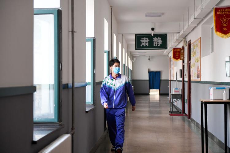 4月7日,一名学生走在长春市东北师范大学附属中学的走廊上.