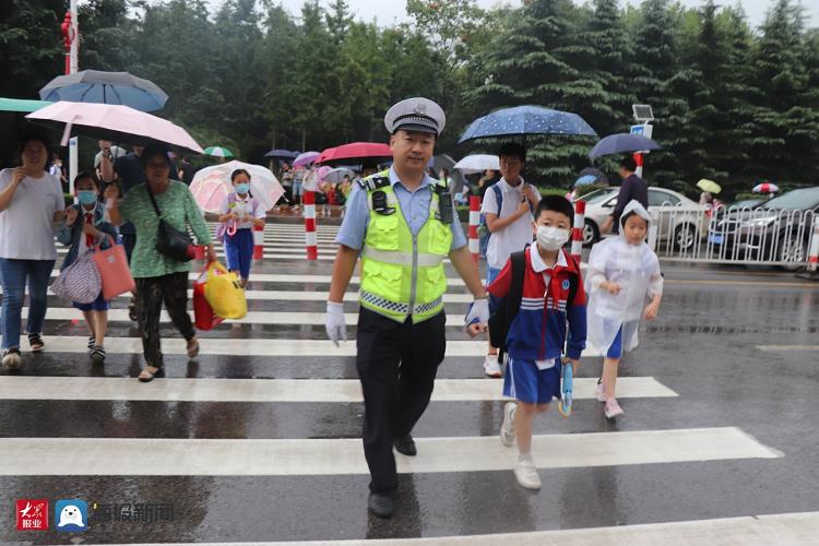 中小学生开学首日城阳交警冒雨守护上学路