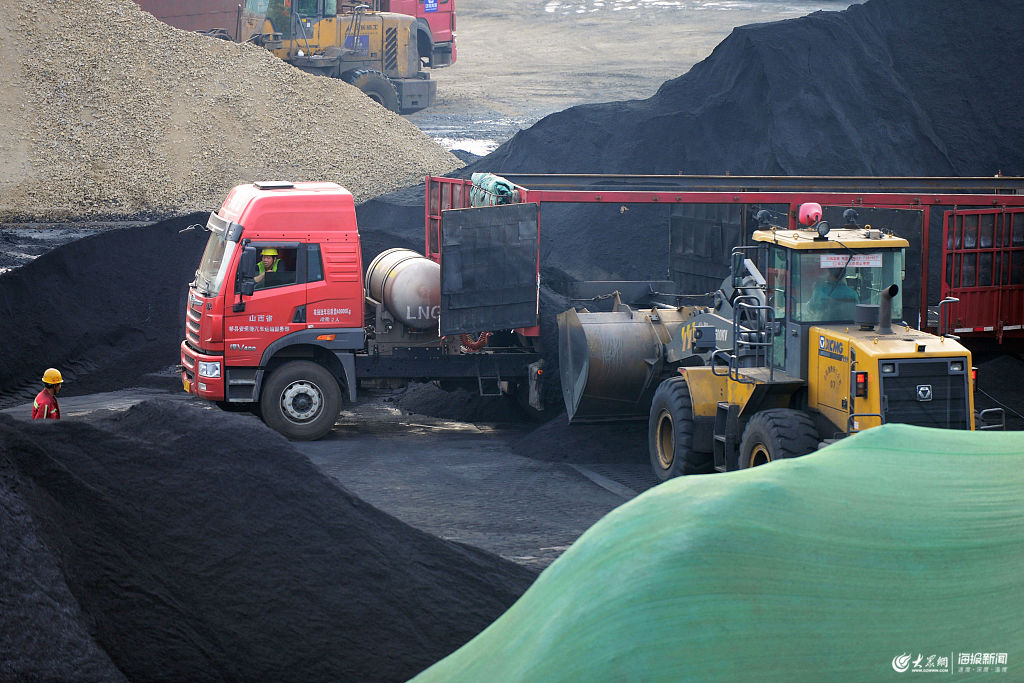 2019年5月15日,山东日照港铁矿石堆场,挖车在堆放进口铁矿石
