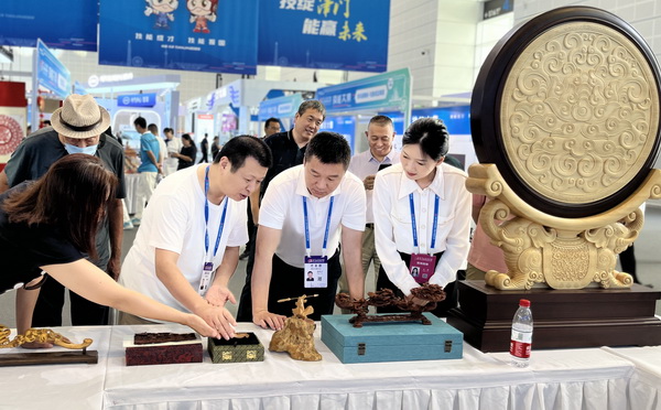 美联红木总设计师胡冠军现场为嘉宾领导和参会者介绍《盛世中华》木雕工艺