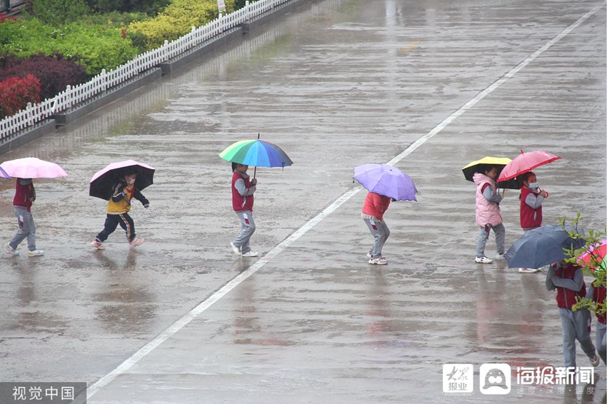 威海迎降雨天气 孩子打伞出行如雨中花朵