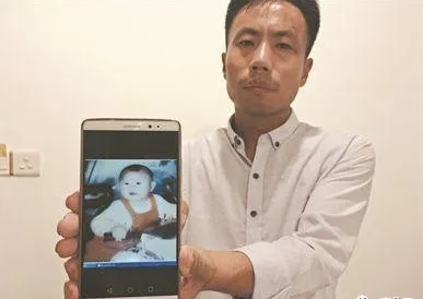 申军良展示儿子的照片。(资料图片)广州日报全媒体记者李波、苏韵桦 摄