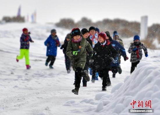 资料图：2019年1月3日，新疆福海县乌伦古湖旁的一处冰雪体验场地，60余名小学生在零下20℃左右的低温环境中上体育课。中新社记者 刘新 摄