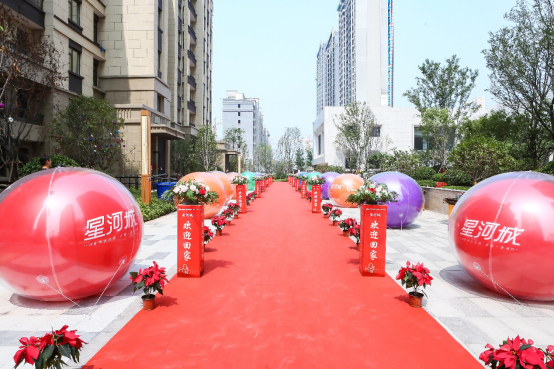 红色的地毯一直延伸到交付现场,印有星河城字样的彩色气球整齐摆放在