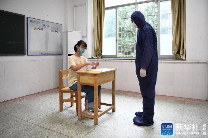 ↑7月3日，工作人员（右）模拟为发热考生安排考试座位。新华社记者 薛宇舸 摄