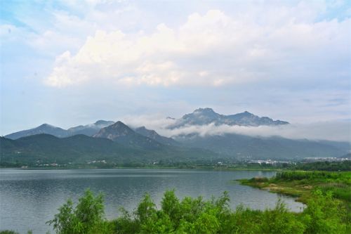 在碧霞湖畔遠望泰山,層層白雲湧現,變幻莫測,時而如同炊煙繚繞籠罩