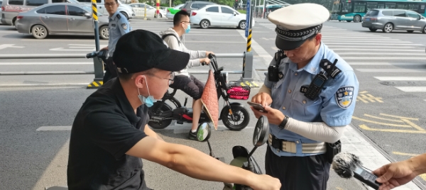 济南交警实行“3选1”模式劝导骑电动车佩戴头盔