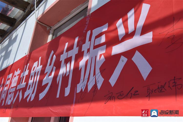 大家在"同心同德共助乡村振兴"的横幅上郑重签字