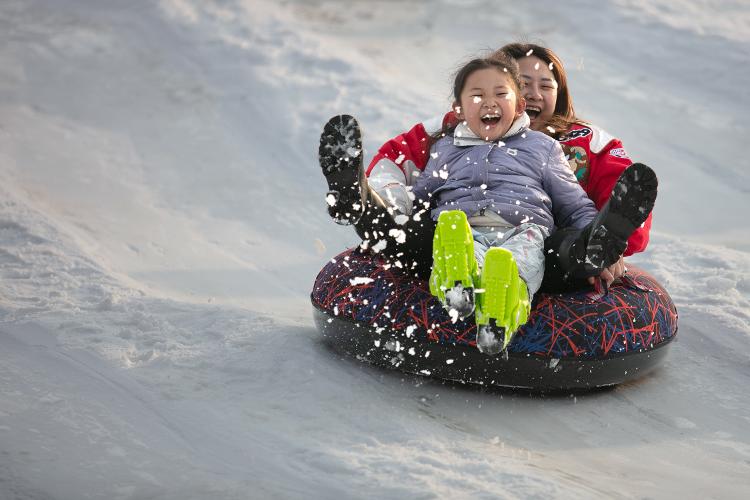 市民在邹城市一家滑雪场享受滑雪圈的乐趣。